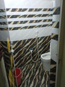 a bathroom with a toilet with a tiger print wallpaper at Saimithra Riverview Homestay in Tirunelveli
