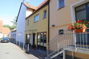 a building with a balcony with flowers on it at Hotel Garni WEISSES LAMM in Erlangen