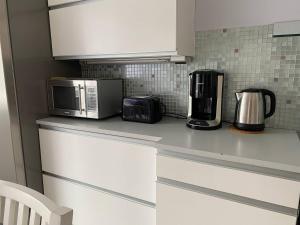 a kitchen counter with a microwave and a coffee maker at Just home in Hamina +4 photos