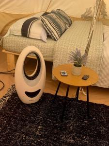 a room with a bed with a table next to a bed at Kama Retreat in Kerpenyest