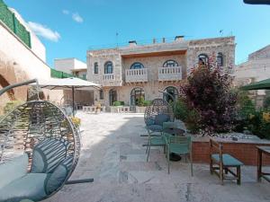 a patio with chairs and tables in front of a building at Cappadocia Chiaro in Uçhisar