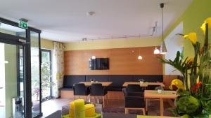 a dining room with tables and chairs and a tv at Hotel Garni WEISSES LAMM in Erlangen