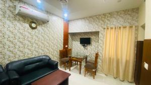a living room with a black couch and a table at Hotel Sky View in Aurangābād