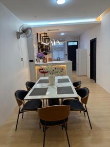 a dining room with a table and chairs and a kitchen at Permai Lake Residence in Sibu