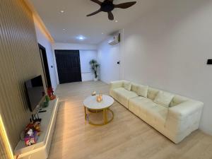 a living room with a white couch and a table at Permai Lake Residence in Sibu