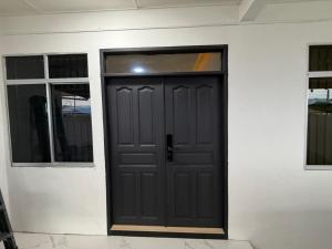 a black door on a white wall with two windows at Permai Lake Residence in Sibu +20 photos