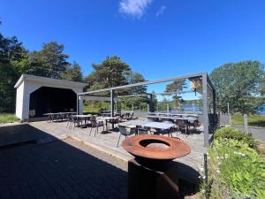 a patio with tables and chairs and a building at Raet Camping in Færvik