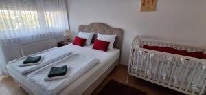 a bedroom with a crib with red and green pillows at Esma 2 in Bihać