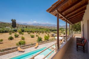 a view from the balcony of a house with a swimming pool at Villa Maragoudi in Arménoi