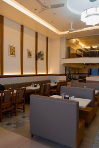 a dining room with tables and chairs in a restaurant at Hotel Serenova, Pune- Pure Veg in Pune