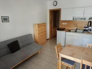 a living room with a couch and a table and a kitchen at Soča Trails Apartment #4 in Srpenica