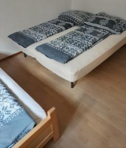 two beds sitting next to each other on a wooden floor at Soča Trails Apartment #4 in Srpenica