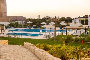 a resort with a swimming pool with umbrellas at Settle inn Jebal apartments in Cairo