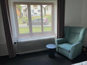 a living room with a chair and a window at Apartmán PASOMA in Levoča