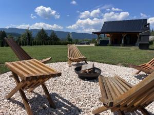 two wooden chairs and a fire pit in a yard at Villa Ema in Pale