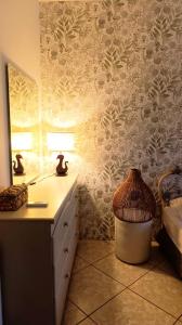 a bedroom with a dresser and a lamp on a wall at Anavyssos Serenity Villa in Anavyssos +23 photos