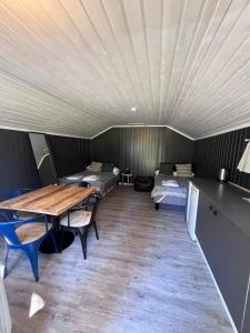 a room with a table and two beds in it at Raet Camping in Færvik