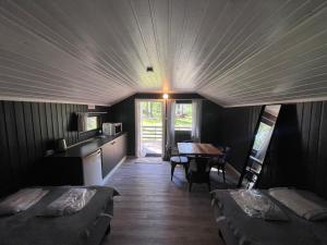 a room with two beds and a table in a room at Raet Camping in Færvik