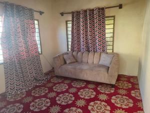 a couch in a living room with curtains and a rug at Shalma House in Lamu