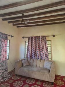 a living room with a couch and two windows at Shalma House in Lamu
