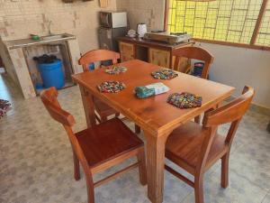 a wooden table with four chairs in a kitchen at Shalma House in Lamu