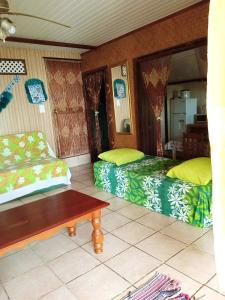 a living room with two beds and a coffee table at Maupiti Authentique in Te-Fare-Arii