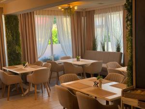 a restaurant with tables and chairs and a window at Harmonie Radauti in Rădăuţi