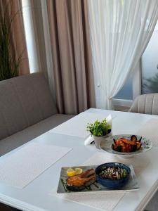 a white table with two plates of food on it at Harmonie Radauti in Rădăuţi +29 photos