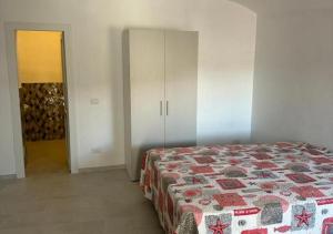 ein Schlafzimmer mit einem Bett, einem Kleiderschrank und einer Tür in der Unterkunft Agenzia Arcipelago Gary 2 in Ponza + 1 Foto