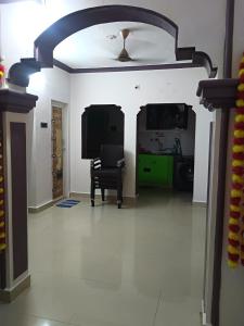 a living room with a tv and a chair at Saimithra Riverview Homestay in Tirunelveli