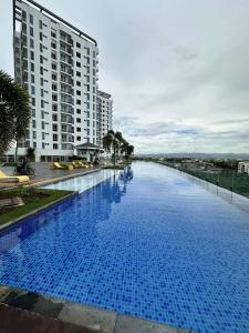 a large blue swimming pool next to a tall building at Mactan Newtown Condo Rentals in Punta Engaño