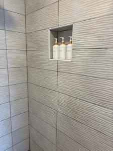 a bathroom with three white bottles on a wall at Aniva in Drage +24 photos