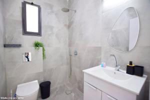 a bathroom with a sink and a toilet and a mirror at וילה מושלמת עם בריכה מפנקת וממ"ד בשכונת טבריה המושבה בעיר טבריה in Tiberias +26 photos