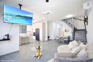 a living room with a couch and a flat screen tv at וילה מושלמת עם בריכה מפנקת וממ"ד בשכונת טבריה המושבה בעיר טבריה in Tiberias
