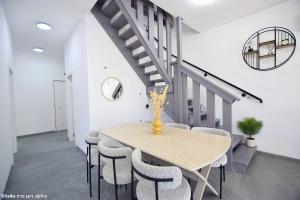 a dining room with a table and chairs and a staircase at וילה מושלמת עם בריכה מפנקת וממ"ד בשכונת טבריה המושבה בעיר טבריה in Tiberias