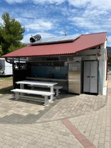 a building with a picnic table in front of it at Camp Mali Baška in Baška