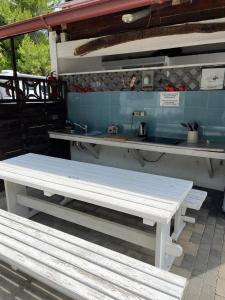 two white benches sitting in front of a kitchen at Camp Mali Baška in Baška