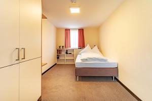 a small bedroom with a bed and a window at Hotel Garni WEISSES LAMM in Erlangen +23 photos