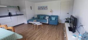 a living room with a blue couch and a table at Apartamento en Casa Playa de Nerga in Hio