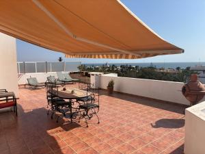 a patio with a table and chairs under a large umbrella at Agadir 1 plage piscine terrasse in Agadir