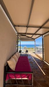 a bed in a room with a view of the ocean at Sadova Messinia Pearl Cozy Seafront House in Avía