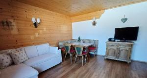 a living room with a couch and a table with chairs at Rauchenberg Apartments in Lofer