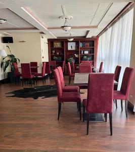 a dining room with red chairs and a table at Hotel Du Col in Sestriere