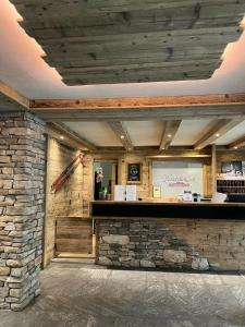 a lobby with a stone wall and a bar at Hotel Du Col in Sestriere