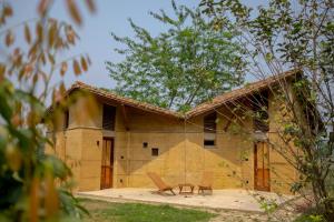 a house with a picnic table in front of it at Tiger Track Eco Lodge in Bardiyā +37 photos