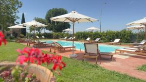 a swimming pool with chairs and umbrellas next to at I Costanti in Caldiero