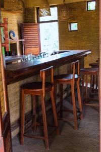 a bar with wooden stools and a large counter at Tiger Track Eco Lodge in Bardiyā