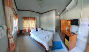 a bedroom with a bed and a television in it at Beyond Pub guest House and Hotel in Ban Tayun