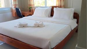 a bed with two white shoes sitting on it at Beyond Pub guest House and Hotel in Ban Tayun +4 photos