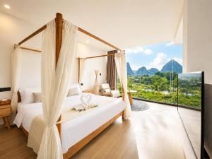 a bedroom with a bed and a large window at Yulong River Scenic Area,Floor-to-ceiling Windows for viewing,Swimming Pool & Coffee & Butler Service,10 minutes by car from West Street in Yangshuo +157 photos